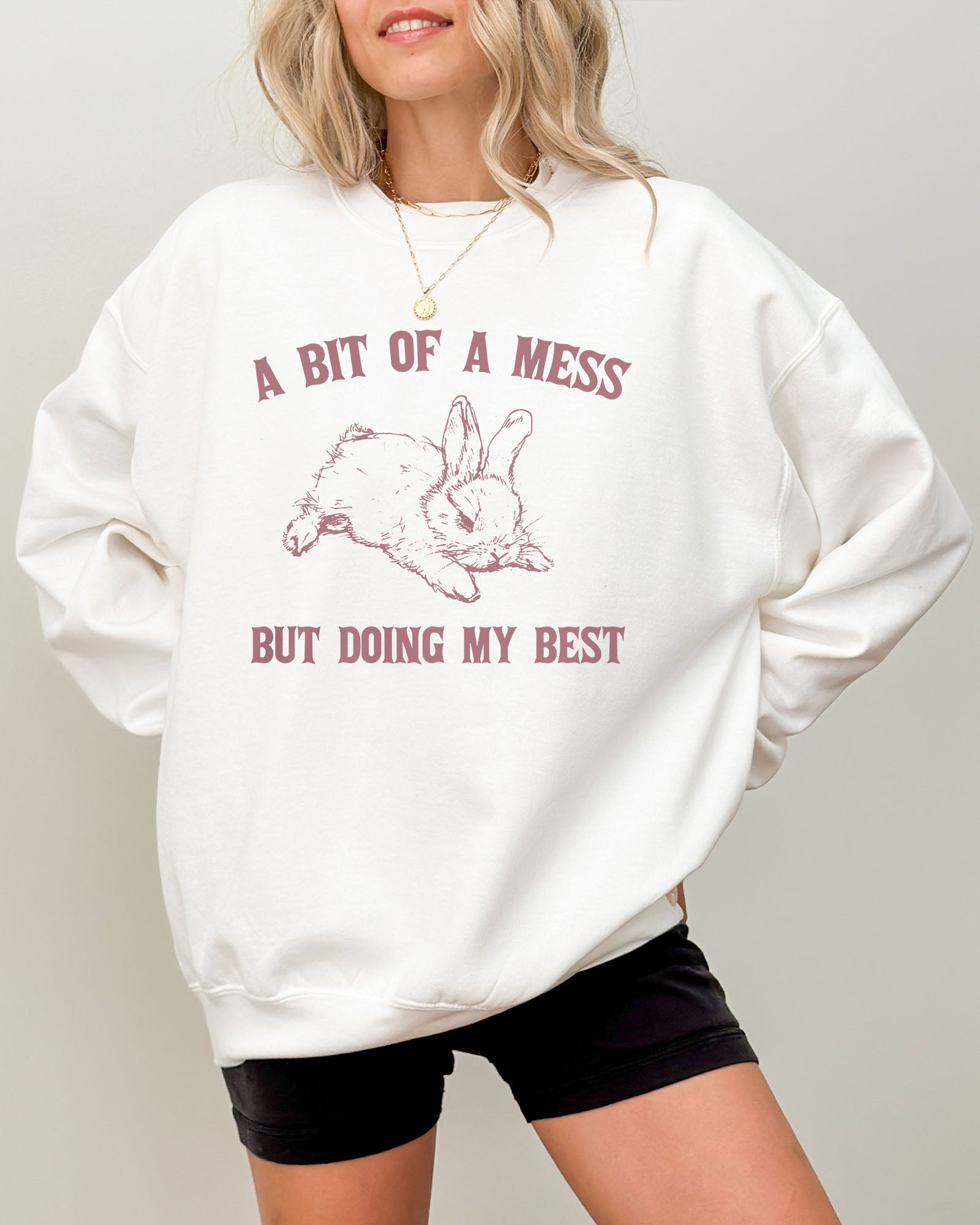 Model wearing white color sweatshirt with 'A Bit Of A Mess But Doing My Best' graphic design