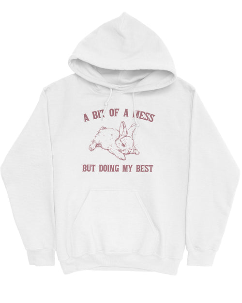 Flat lay of a white hoodie featuring the phrase 'A Bit Of A Mess But Doing My Best' with a retro bunny line art graphic.